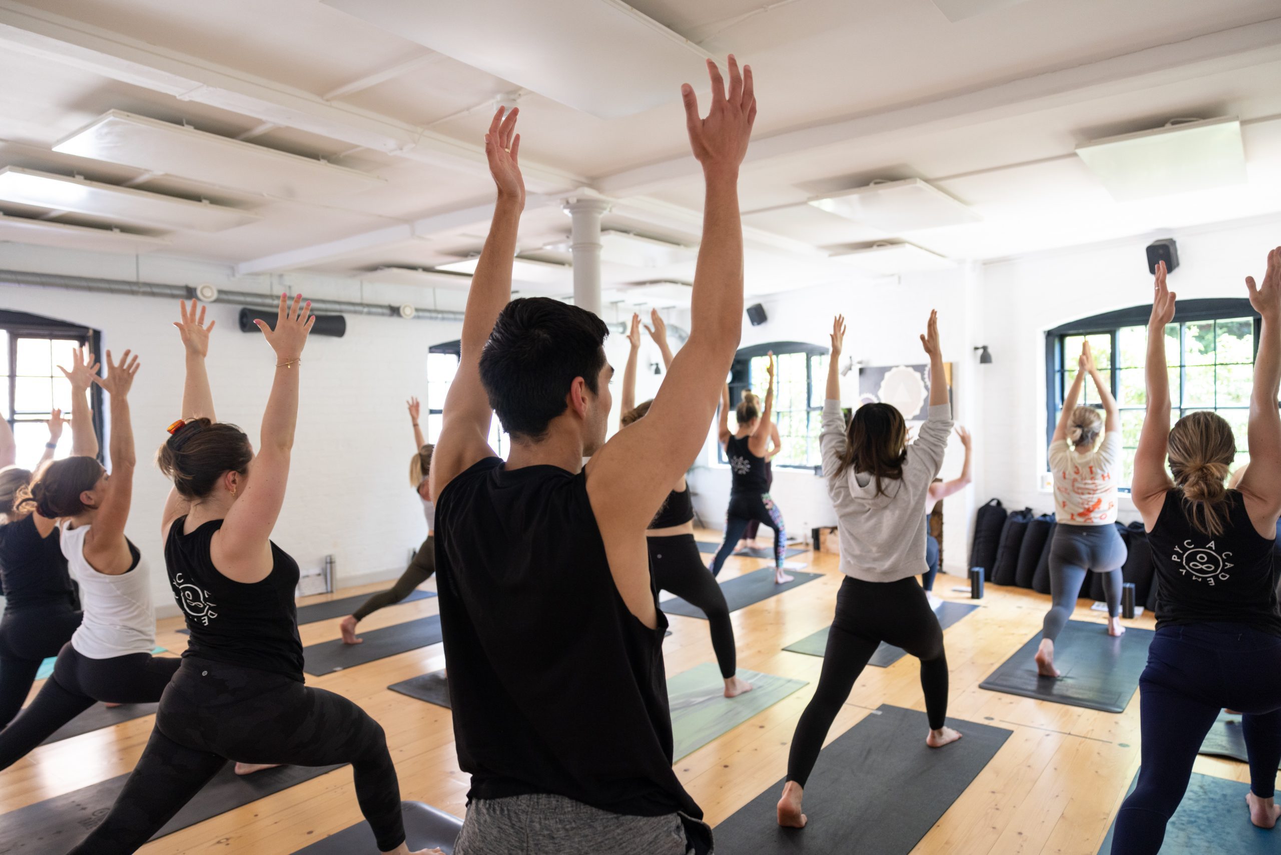 Why Mobility Is Becoming Just As Important As Strength Training 1 A class reaching arms overhead in a bright studio
