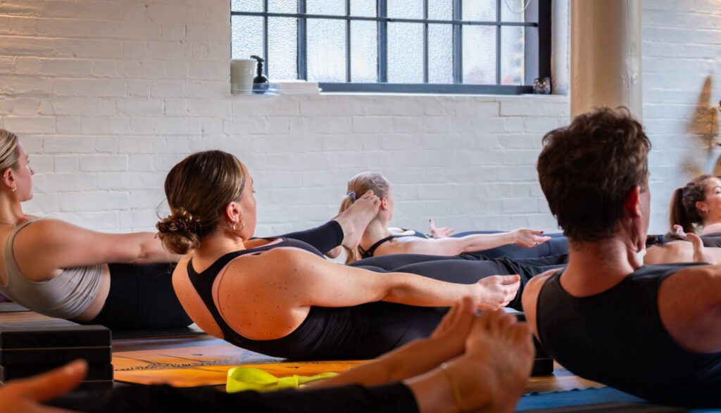 A class using straps in a seated forward fold
