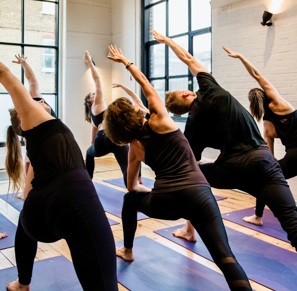 A class holding triangle pose on mats